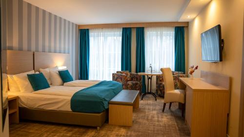 a hotel room with a bed and a desk at Heide Hotel Reinstorf in Reinstorf