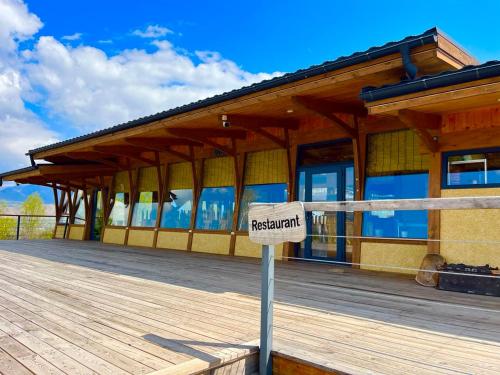 a wooden building with a restaurant sign in front of it at Kemin Guest House in Tar-Suu