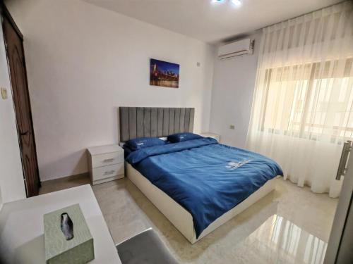 une chambre avec un lit, une table et une fenêtre dans l'établissement Khalda One Bedroom Apt, à Amman