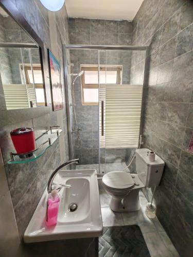 une salle de bains avec lavabo et toilettes dans l'établissement Khalda One Bedroom Apt, à Amman