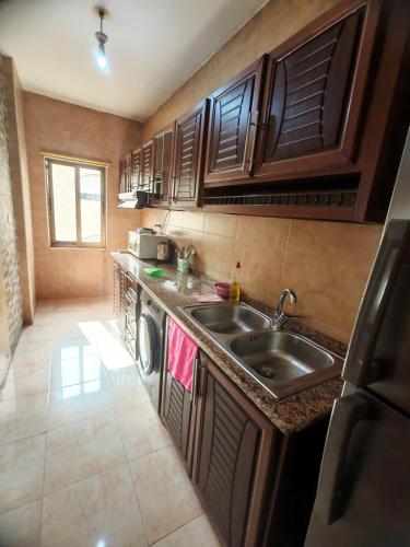 une petite cuisine avec un évier et un lave-vaisselle dans l'établissement Khalda One Bedroom Apt, à Amman
