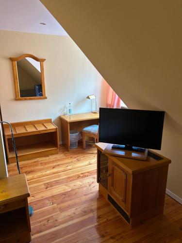 a living room with a flat screen tv on a table at Heide Hotel Reinstorf in Reinstorf