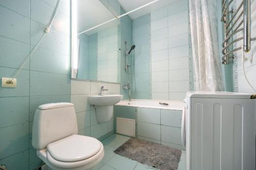 a bathroom with a toilet and a tub and a sink at Evropeiska Street Apartment in Odesa
