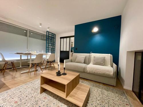 un salon avec un canapé et un mur bleu dans l'établissement Apt 4 Guests Moderne Place Breteuil, à Paris