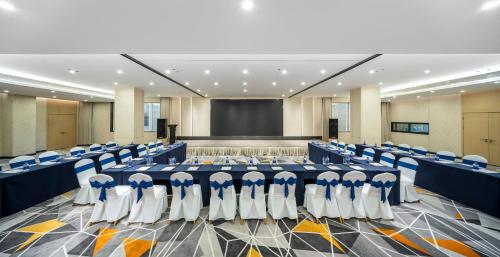 a conference room with blue and white chairs and a screen at Holiday Inn Express Chengdu Tianfu Square by IHG - Chunxi Road and Kuanzhai Alley in Chengdu