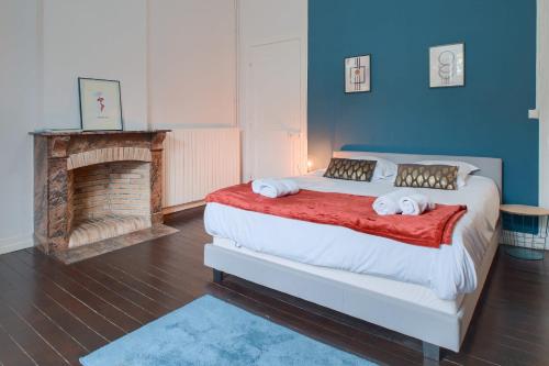 - une chambre avec un grand lit et une cheminée dans l'établissement Le Coty - Wifi - Balcon - Parking, à Laval