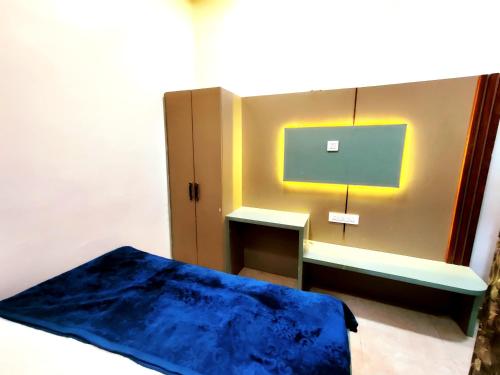 a bedroom with a bed and a desk with a monitor at Shri Banke Bihari Seva Sadan Vrindavan in Vrindāvan