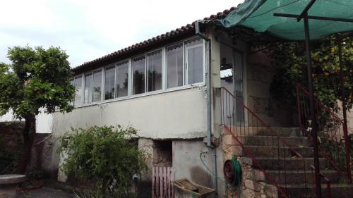 a white house with a door and some stairs at Casa da Rosa in Póvoa de Rio de Moinhos