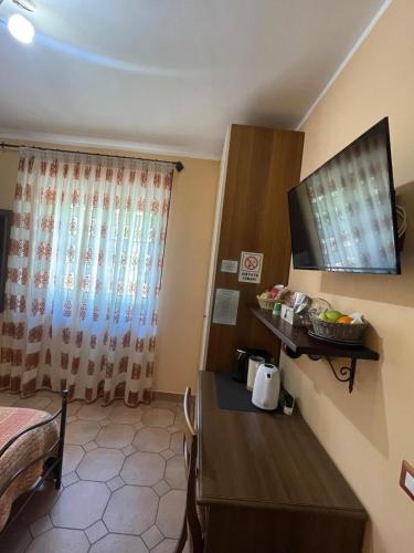 a hotel room with a table and a television at Villa Russo in Caltanissetta
