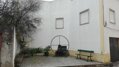 a bench and a mirror in front of a building at Casa da Rosa in Póvoa de Rio de Moinhos