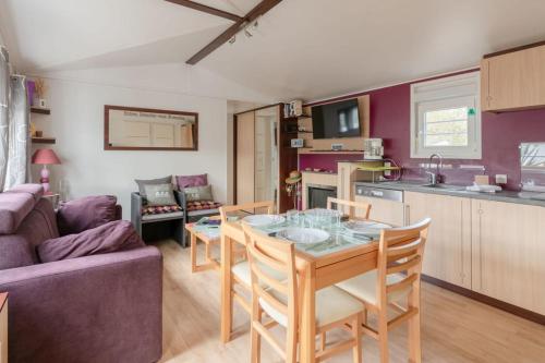 a kitchen and living room with a table and chairs at Bois d'amour - Piscine - Terrasse in Dinard