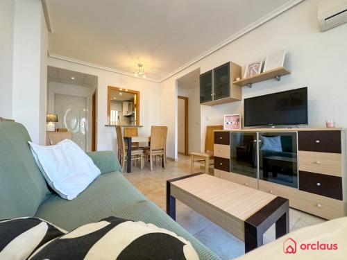 a living room with a green couch and a tv at Rincón Ideal in Oropesa del Mar