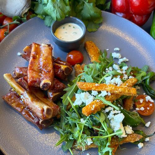 a plate of food with meat and a salad at Qubus Hotel Kraków in Kraków