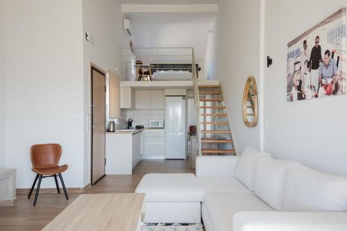 a white living room with a white couch and a kitchen at Amar V in Lechaio