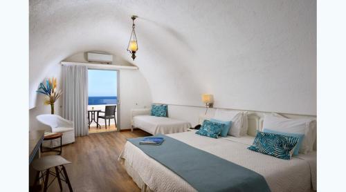 a bedroom with a bed and a room with a view of the ocean at Istron Bay Hotel in Istron