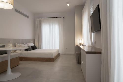 a hotel room with a bed and a television at enδόtera chios apartments in Chios