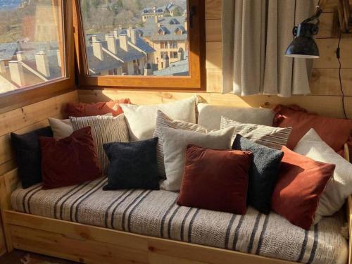 a couch with a bunch of pillows on it at Vistas by Cardi Suites in Panticosa