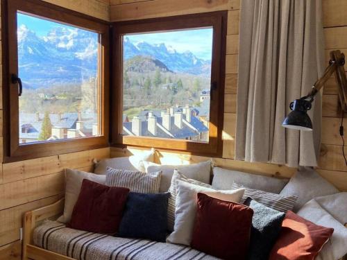 a couch in a room with two large windows at Vistas by Cardi Suites in Panticosa