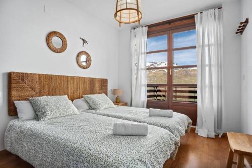 a bedroom with two beds and a large window at Garbo by Cardi Suites in Formigal