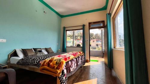a bedroom with a bed in a room with a window at Shiva heights Trek and stay in Chopta
