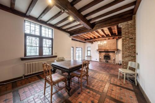 a dining room with a table and a fireplace at Luxury Villa Schaffen with a private gym in Diest