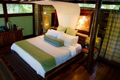 a bedroom with a bed with white sheets and pillows at Morgan's Rock in San Juan del Sur