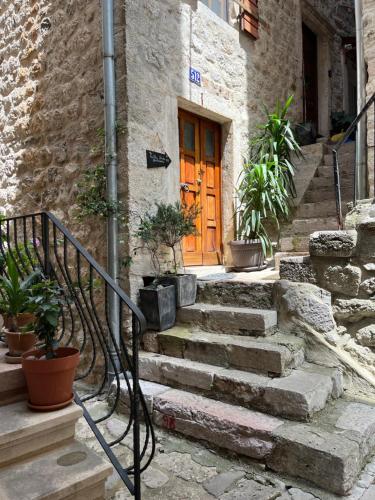 a stone building with a wooden door and stairs at HealthyStudio512 Apartments in Kotor