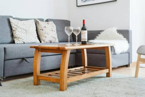 a wine bottle and two wine glasses on a coffee table at Olympia by Cardi Suites in Formigal
