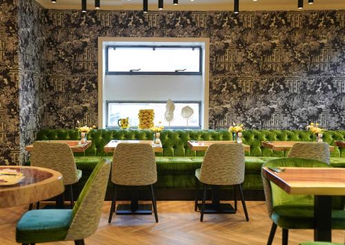 a restaurant with green chairs and a window at De oude gevangenis Almelo in Almelo