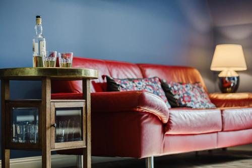 a living room with a red couch and a table at Blue House SPA & JACUZZI Poznań in Poznań