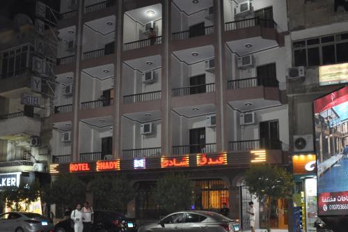 a tall building with cars parked in front of it at Shady Hotel Luxor in Luxor