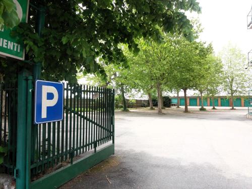 a blue parking sign on a gate next to a parking lot at Hotel Panorama in Cambiano
