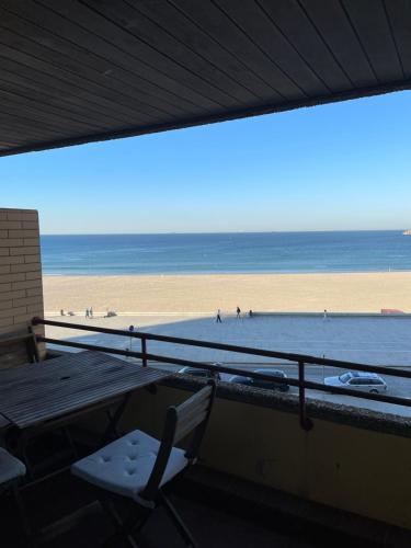 a table and a chair on the beach at Porto - Sunset flat at the beach - Free parking in Matosinhos