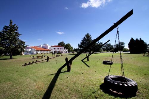 a tire swing in a field with a park at La Campiña Club Hotel & Spa in Santa Rosa