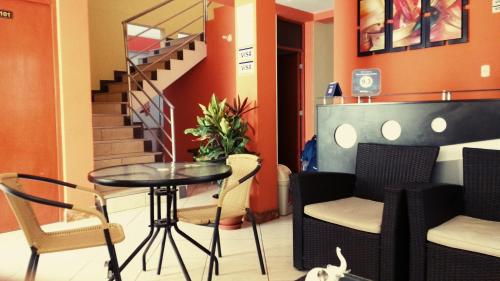 a room with a table and chairs and a staircase at Nasca Travel One Hostel in Nazca