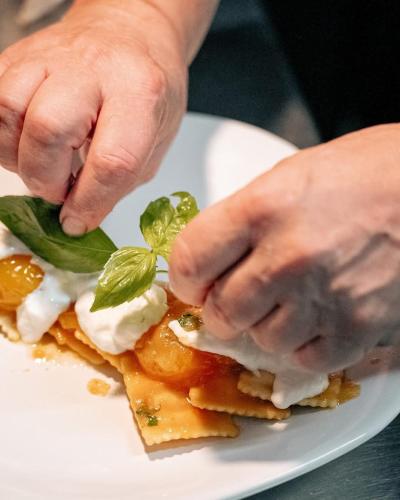 a person is putting a leaf on a plate of food at Tenuta Ferraro Gallipoli in Gallipoli