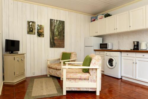 a kitchen with a table and a chair and a microwave at Quinta das Acácias in Livramento