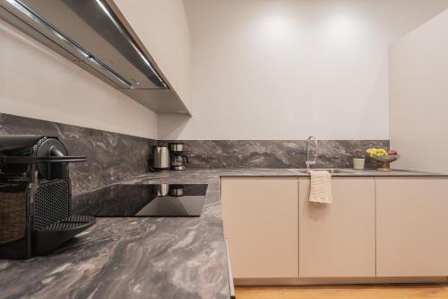 a kitchen with white cabinets and a sink at Rezia Apartments by Rent All Como in Como
