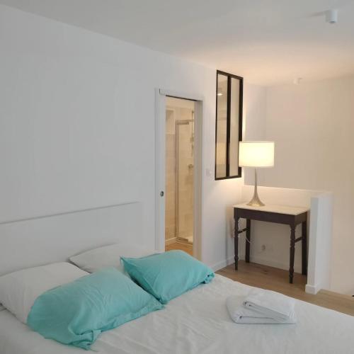 - une chambre avec un lit doté d'une lampe et d'une table dans l'établissement BORD de MER au COEUR de Bénodet, beau duplex contemporain tout equipe, à Bénodet