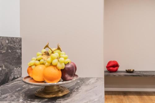 a bowl of fruit on a plate on a table at Rezia Apartments by Rent All Como in Como