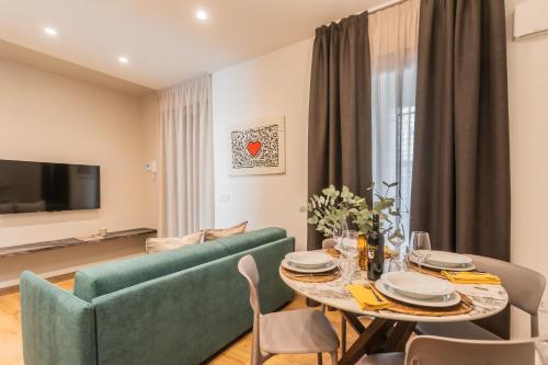 a living room with a green couch and a table at Rezia Apartments by Rent All Como in Como