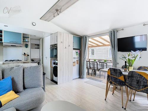 un salon avec un canapé et une table dans l'établissement Mobil-Home FO 49 à Vias - La Carabasse - Camping Siblu avec piscine, à Vias