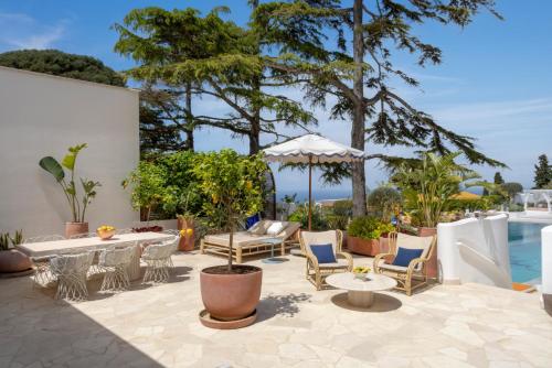 a patio with a table and chairs and a pool at Jumeirah Capri Palace in Anacapri