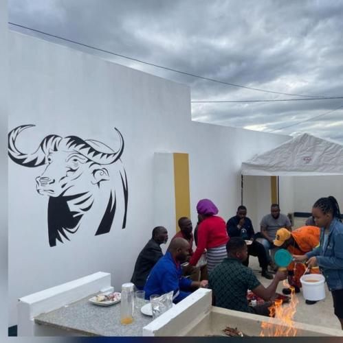a group of people sitting around a table in a room at Nogixa Lodge in Umzimkulu