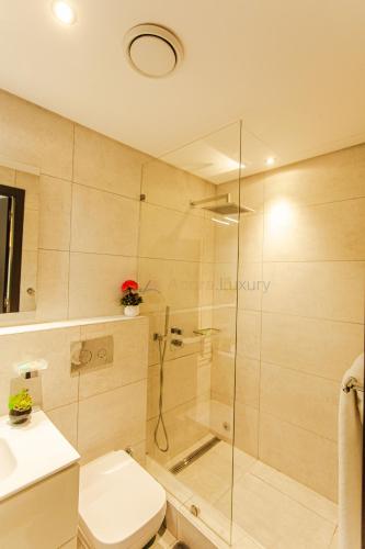 a bathroom with a shower and a toilet and a sink at Accra Luxury Apartments @ The Signature in Accra