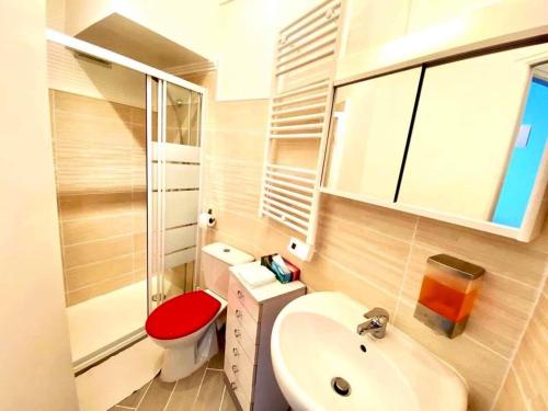 une salle de bain avec des toilettes rouges et un lavabo dans l'établissement Joli studio cœur de Nice, à Nice