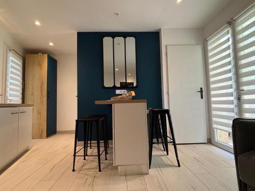 a kitchen with blue walls and a counter with stools at Les Lodges de Saint-Cassien 3 in Montauroux