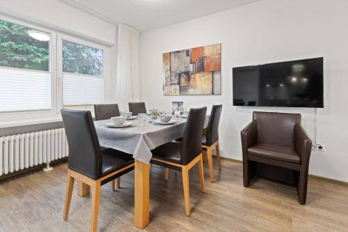 ルストにあるApartments Münchbach - near Europa-Park and Rulanticaのテーブルと椅子とテレビのあるダイニングルーム