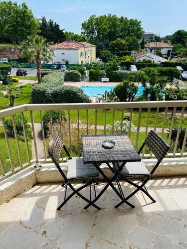 a table and two chairs sitting on a balcony at Studio de standing climatisé, avec piscine, proche de la mer in Fréjus