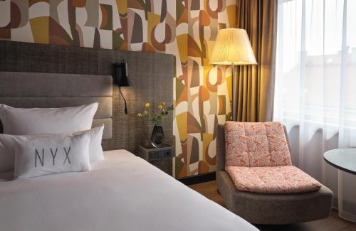 a hotel room with a bed and a chair at NYX Hotel Berlin Köpenick by Leonardo Hotels in Berlin